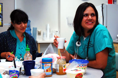 Taking a coffee break with coworkers.  Delia says it's a communal atmosphere  in her department of nurses.  "Everyone shares here."  