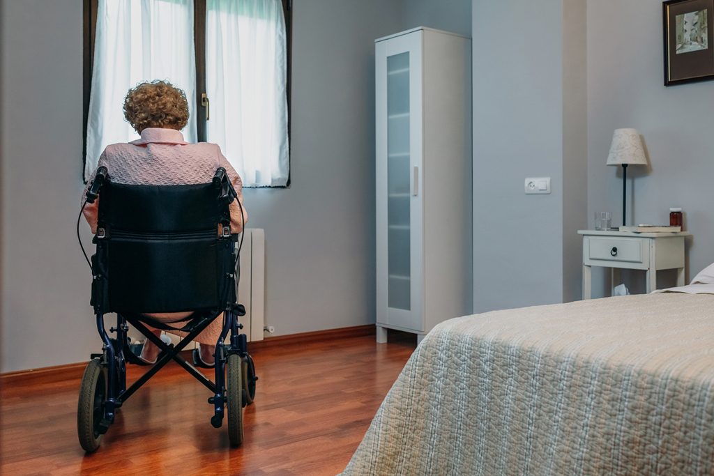 Senior woman in a wheelchair alone in a room